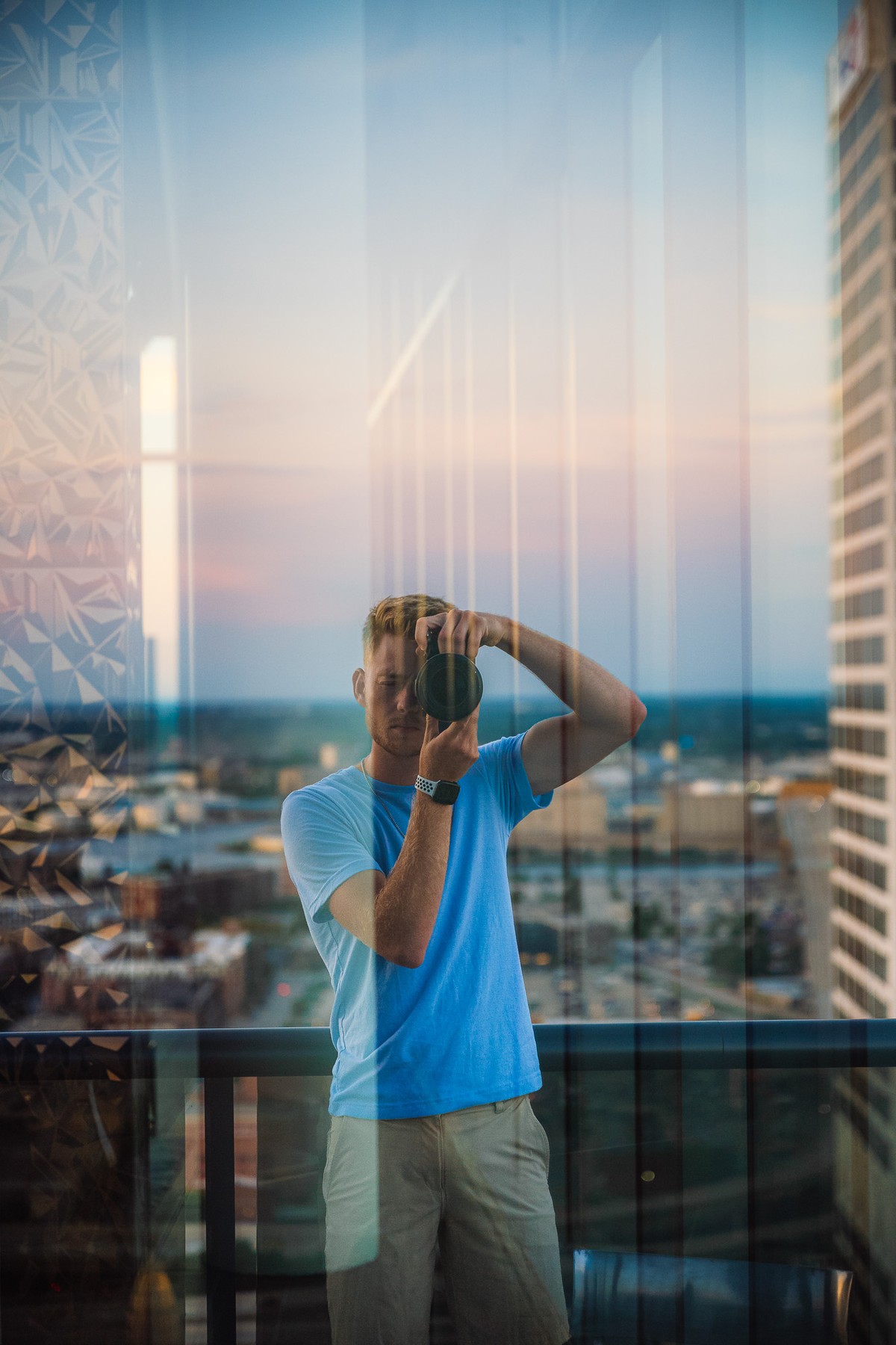 Zac Rains photographing from a high-rise overlooking the city